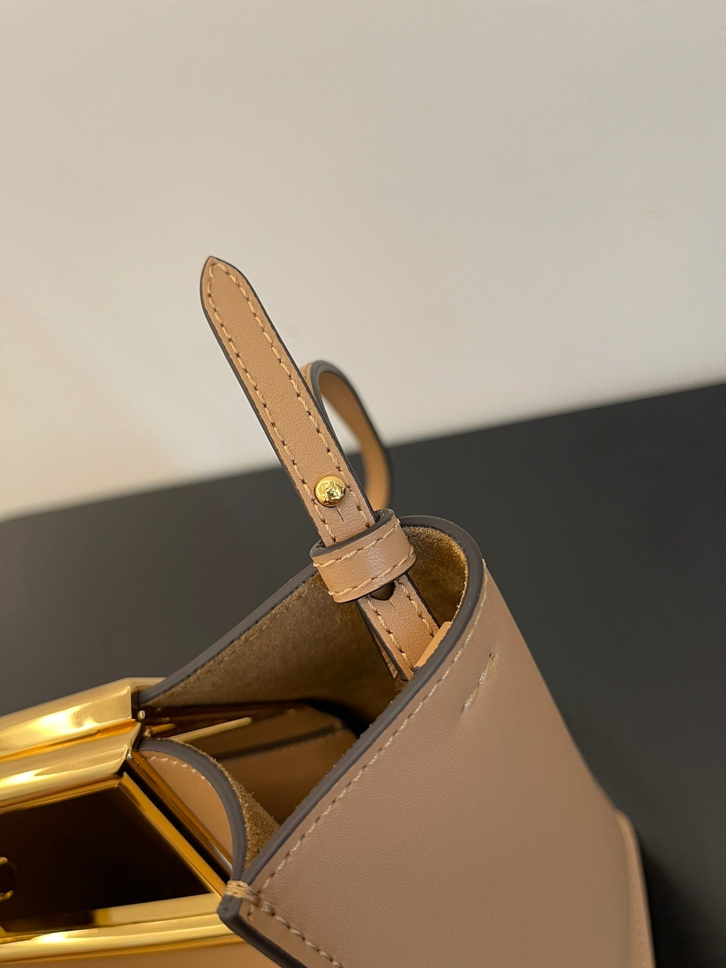 Tan Leather Bucket Bag with Gold Geometric Clasp and Shoulder Strap